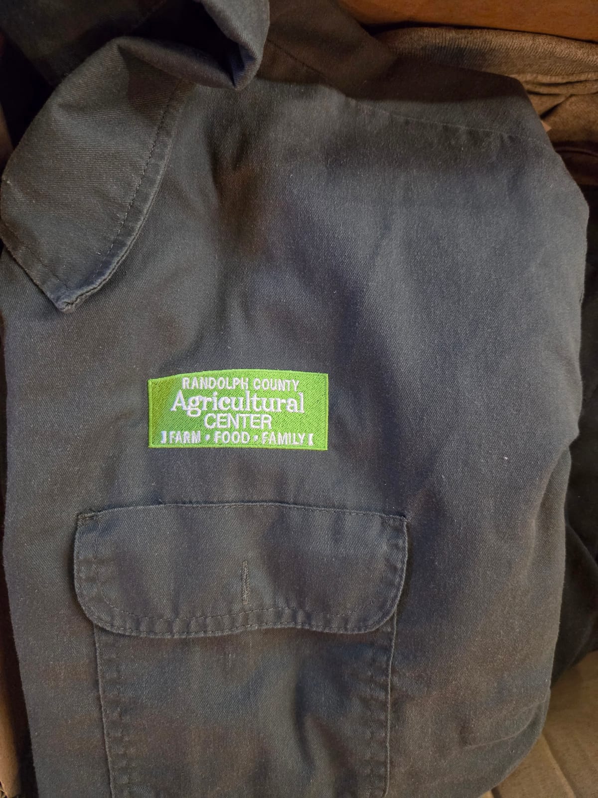 Embroidered Randolph County Agricultural Center badge on a work shirt