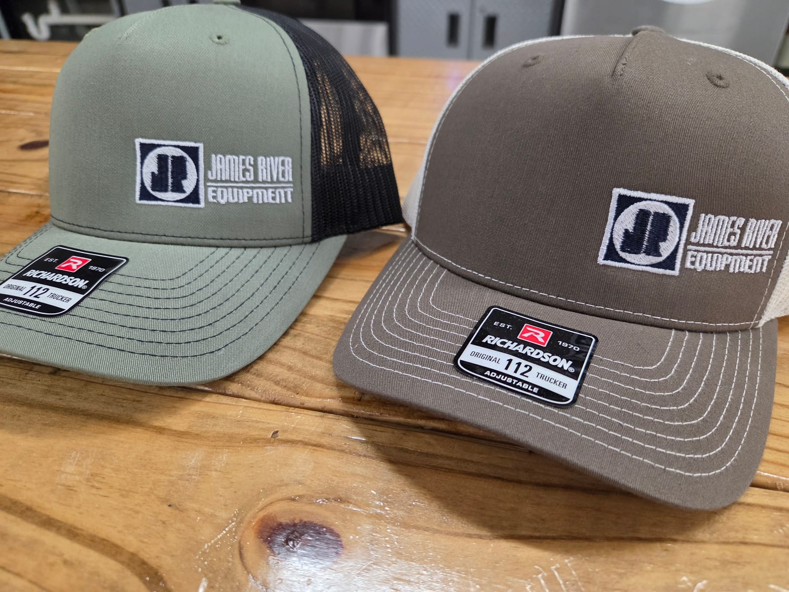 Embroidered James River Equipment logo on two trucker hats